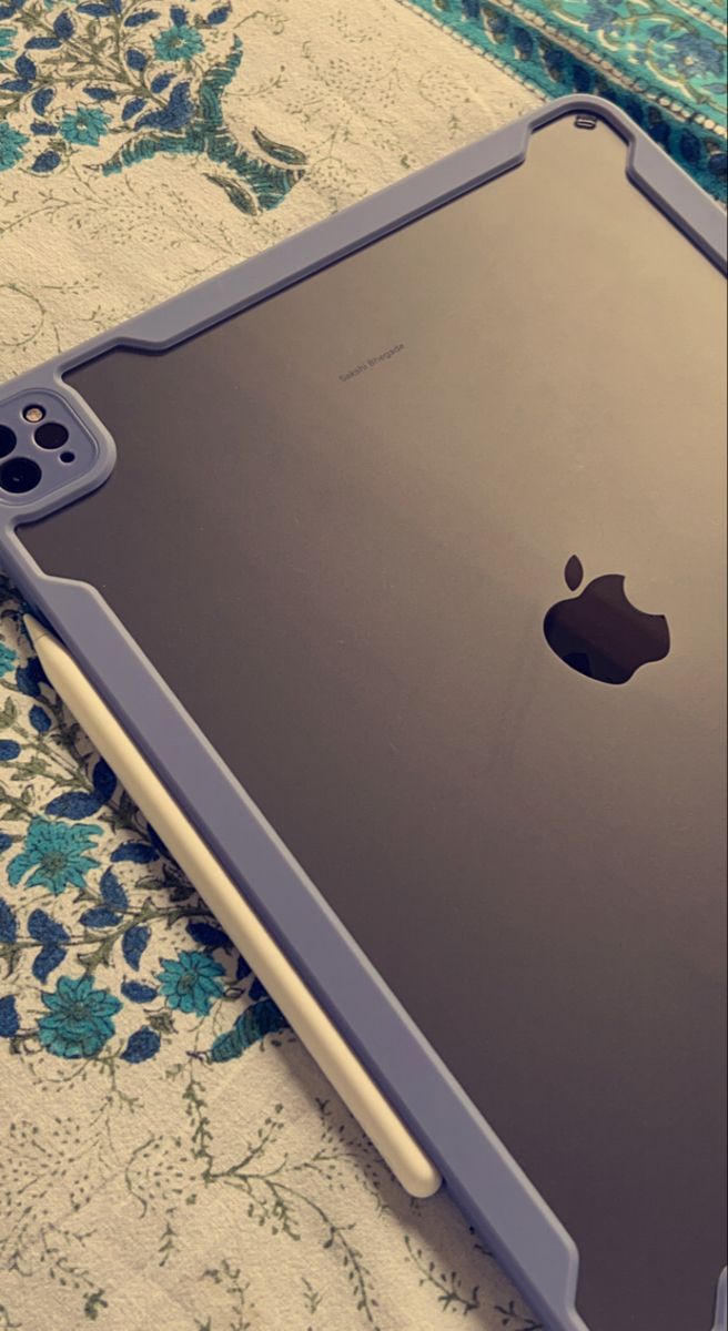 an ipad case sitting on top of a floral print table cloth with the cover partially open