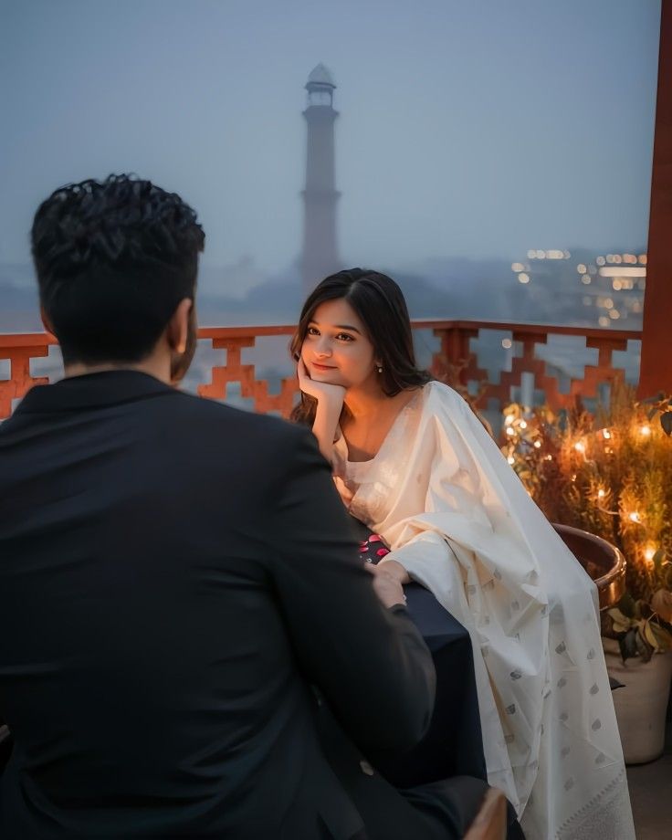 a man sitting next to a woman on top of a balcony