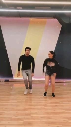 two people are dancing on a wooden floor