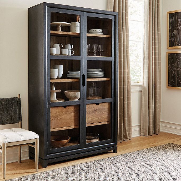 a wooden cabinet with glass doors in a living room