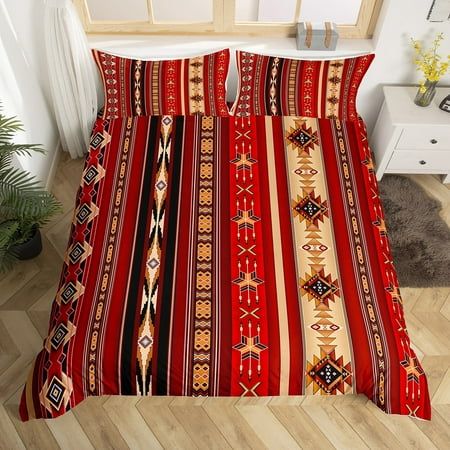 a bed with red and yellow striped comforter set on top of a wooden floor