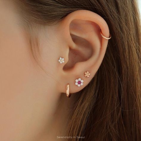 a woman's ear with three small flowers on it