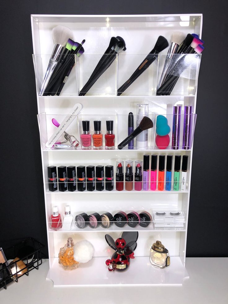 a white shelf filled with lots of different types of makeup