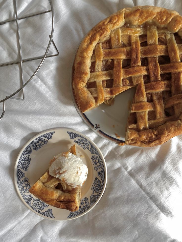 two pies sitting on top of a table next to a plate with ice cream