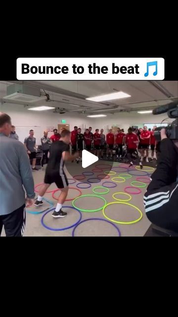 a group of people standing in a room with circles on the floor