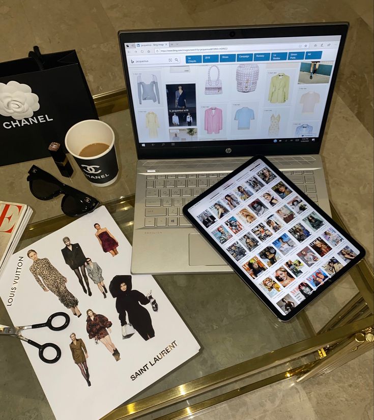 an open laptop computer sitting on top of a glass table next to a cup of coffee