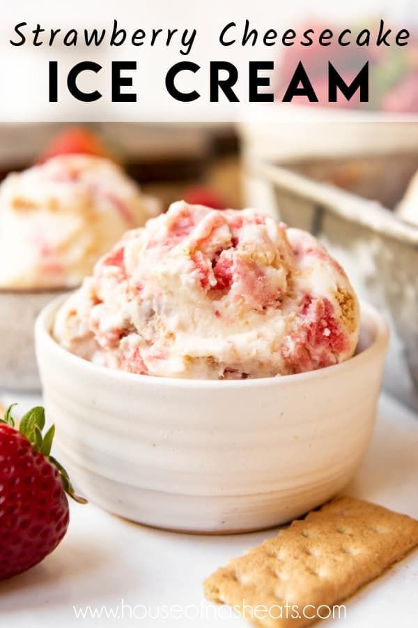 strawberry cheesecake ice cream in a bowl with crackers and strawberries on the side