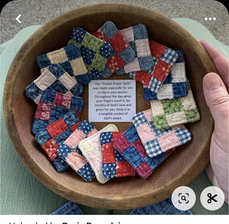 a wooden bowl filled with small patchwork pieces