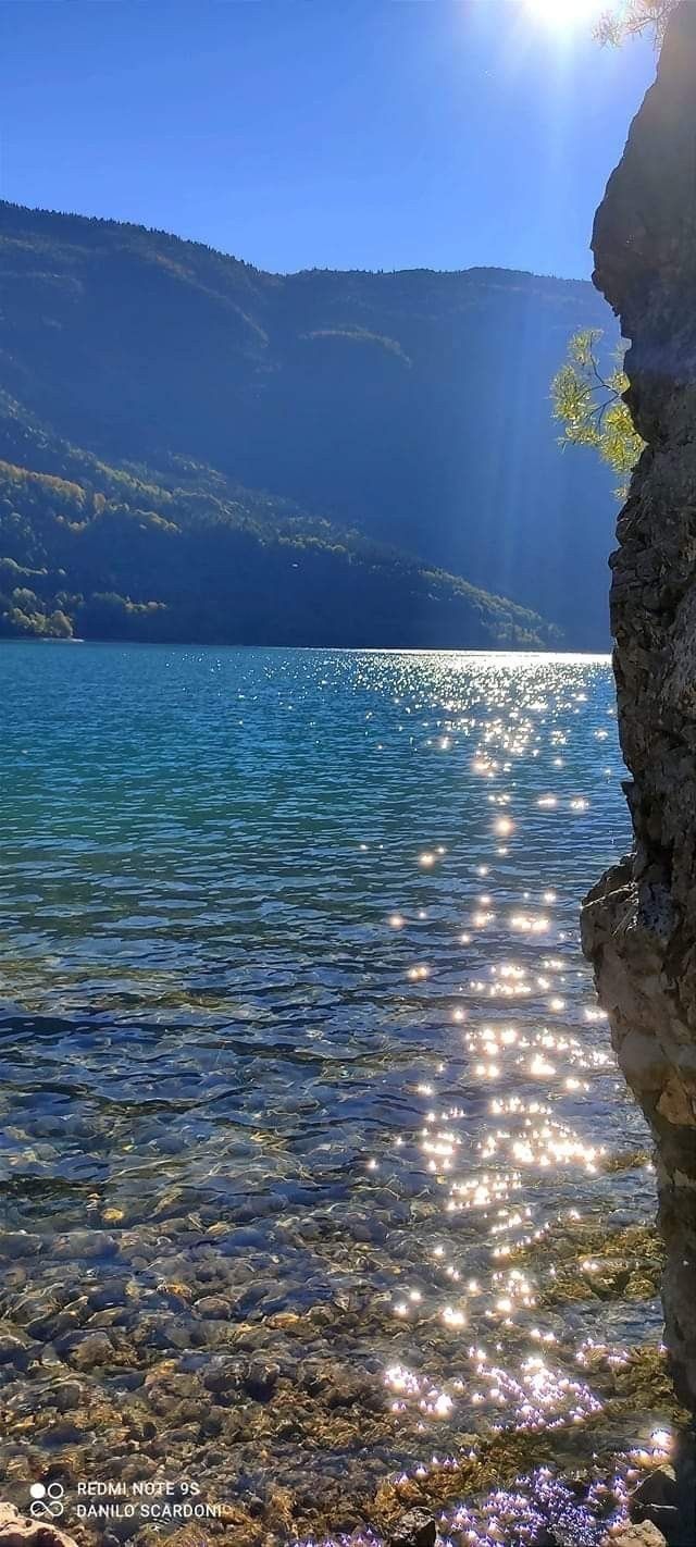 the sun shines brightly on water and rocks