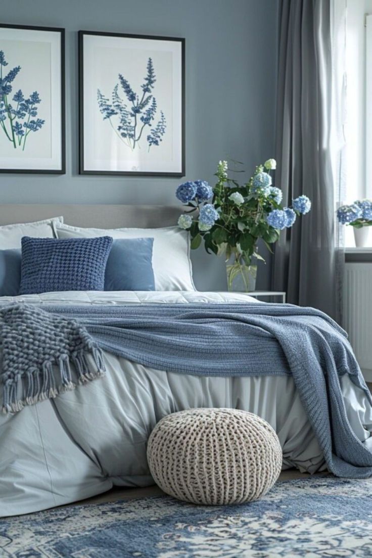 a bedroom with blue and white decor on the walls, bedding, and pillows