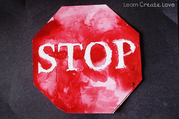 a red stop sign with the word stop painted on it