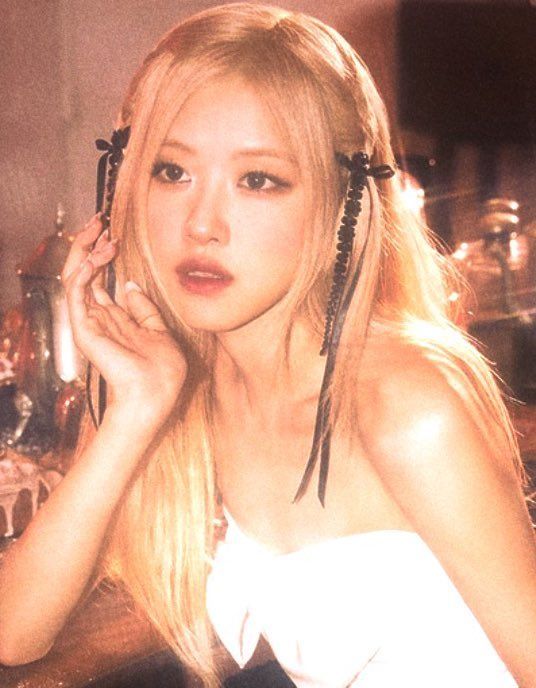 a woman with long blonde hair sitting at a table