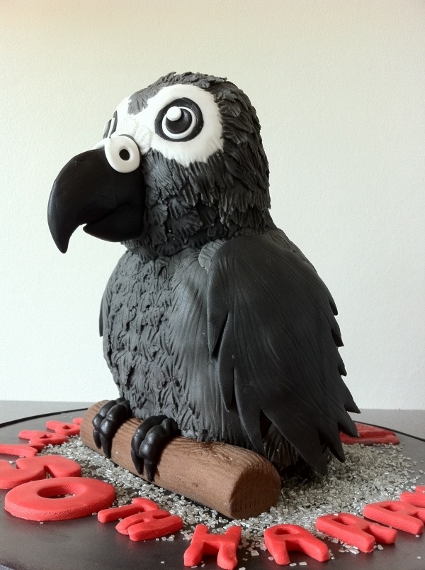 a cake with a bird on top of it and the word boo spelled out in red letters