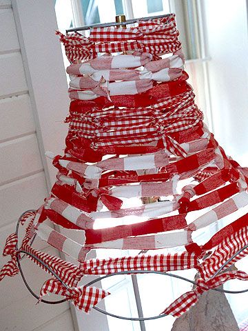 a red and white christmas tree made out of strips of paper on a wire rack