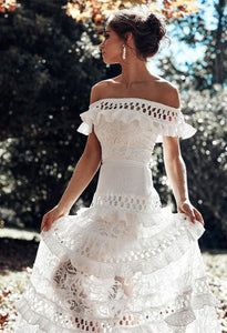 a woman in a white dress walking through leaves