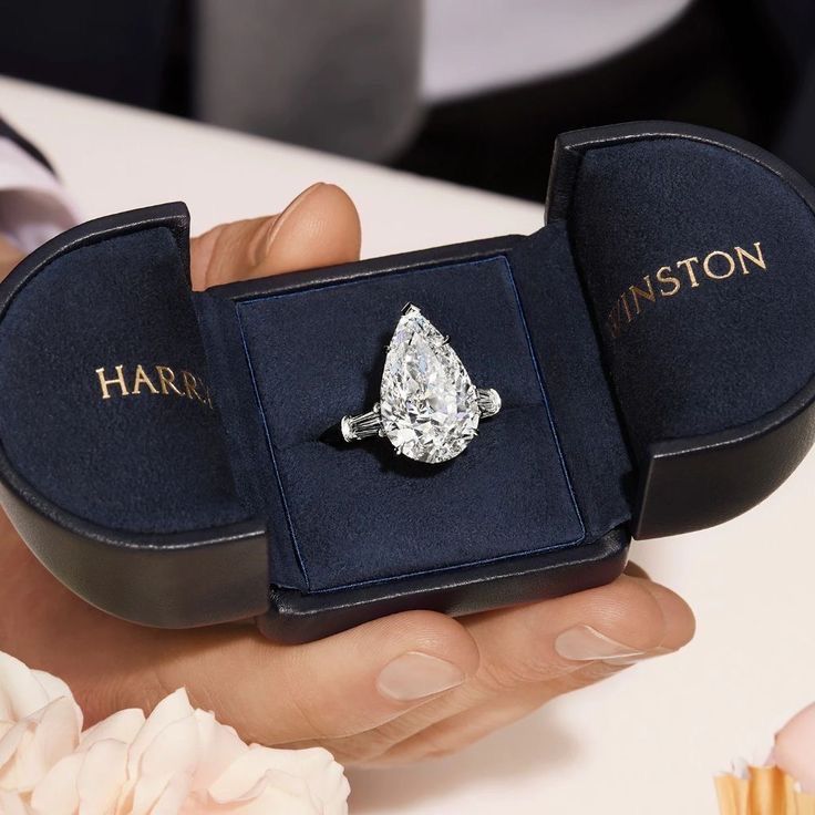 a person holding an engagement ring in a box with the word, harrison on it