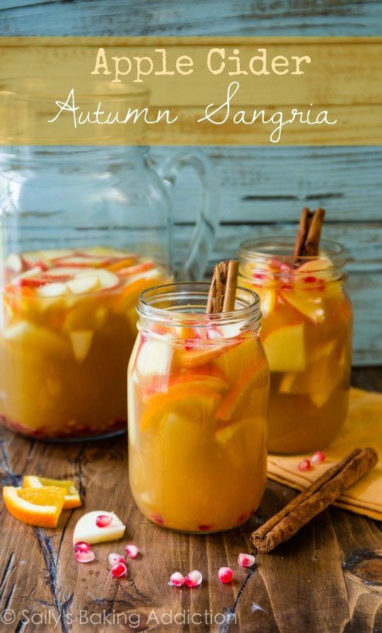 two jars filled with apples and cinnamon on top of a wooden table