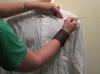 a man is cutting his shirt with scissors