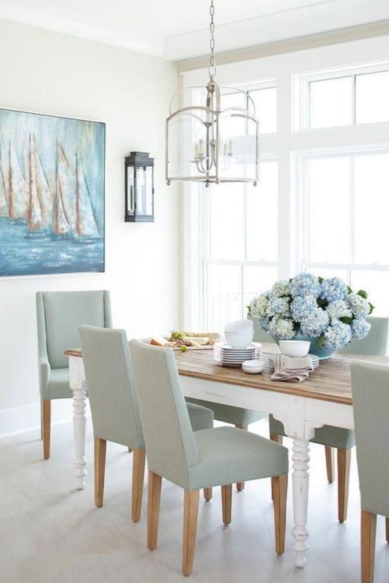 a dining room table with chairs and a painting on the wall