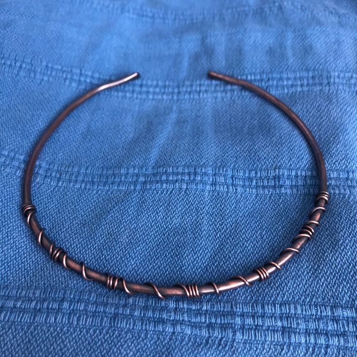 a close up of a metal bracelet on a blue cloth