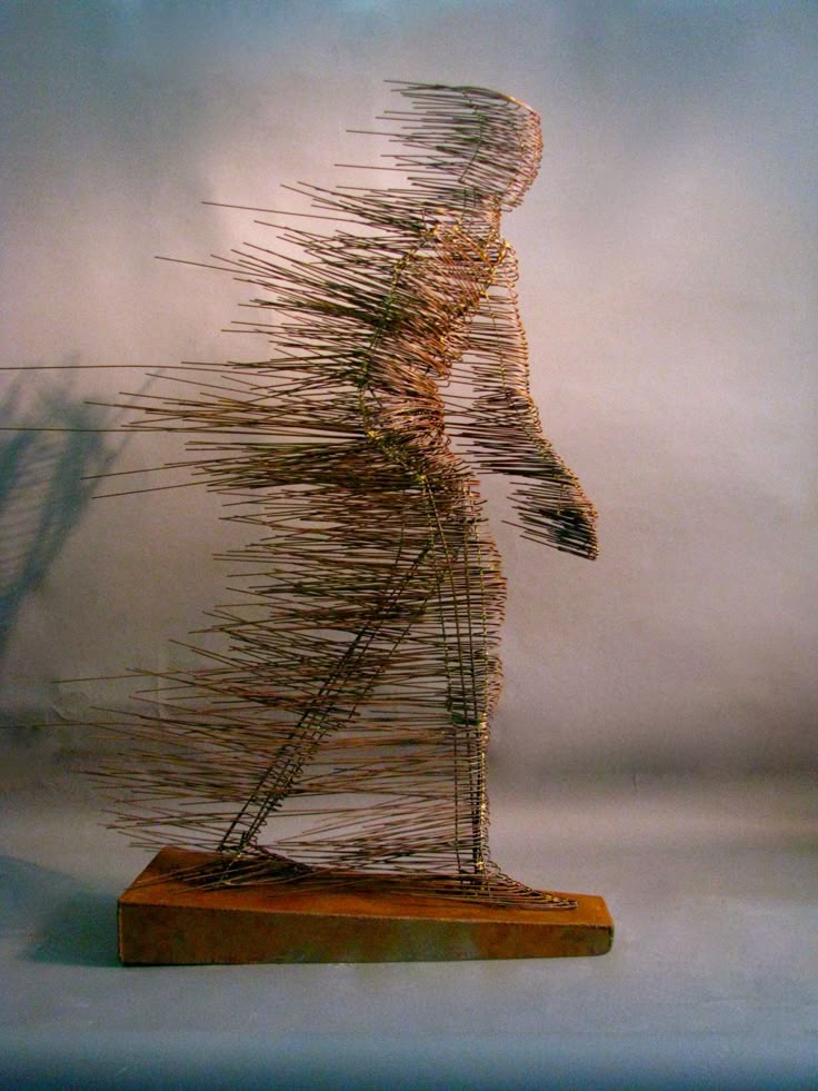 a sculpture made out of branches on a wooden base