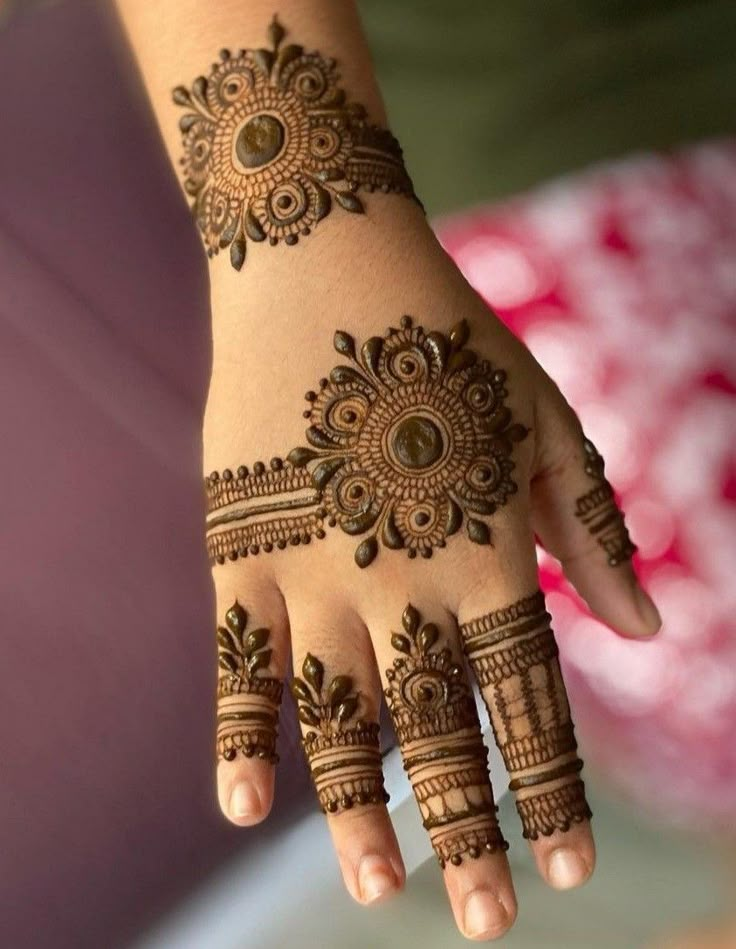 a woman's hand with hennap on her arm and hands, showing the intricate