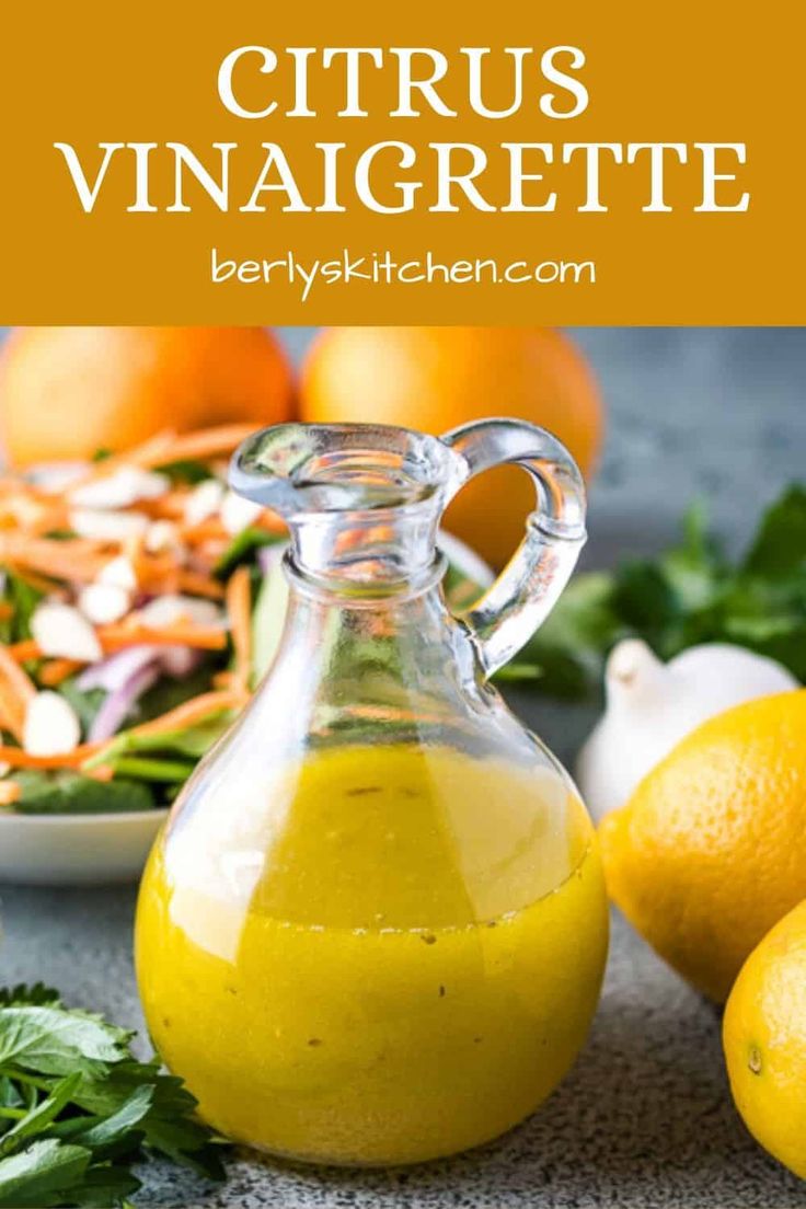 citrus vinaigrete in a glass pitcher next to lemons and parsley