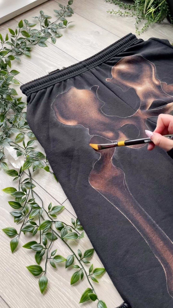 someone is using scissors to cut out an image on the side of a black skirt