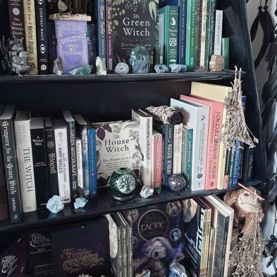 a book shelf filled with lots of books next to a wall covered in halloween decorations