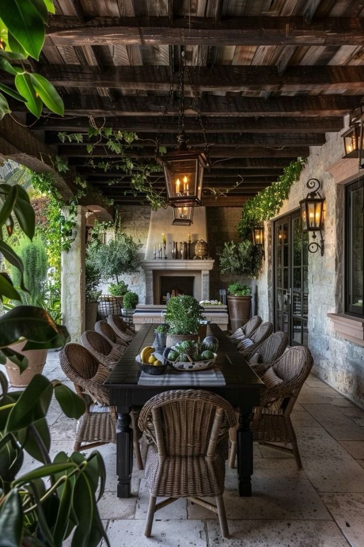 an outdoor dining area with wicker furniture and potted plants on the patio table