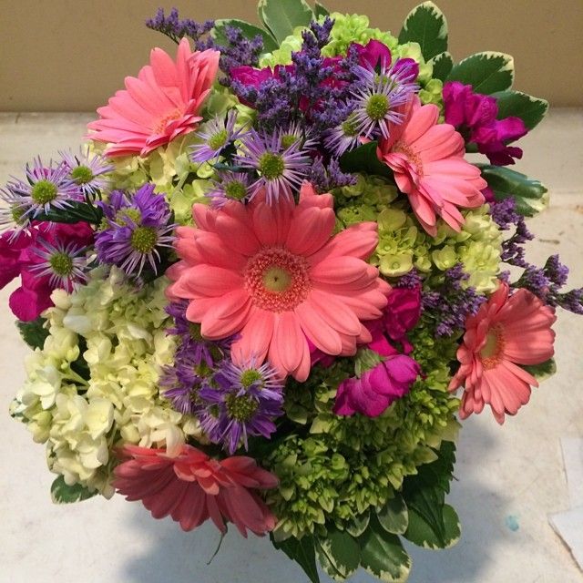 a vase filled with lots of different colored flowers