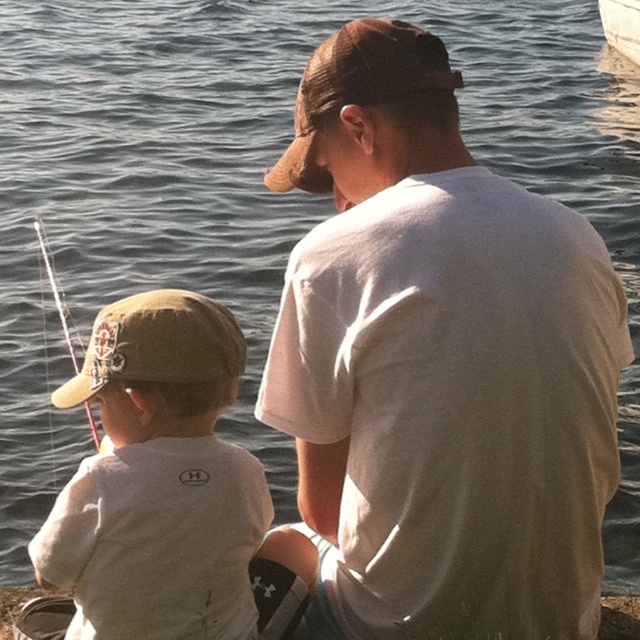 a father and son fishing on the lake