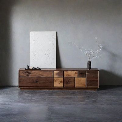 an empty room with a wooden cabinet and vase on the floor next to a painting