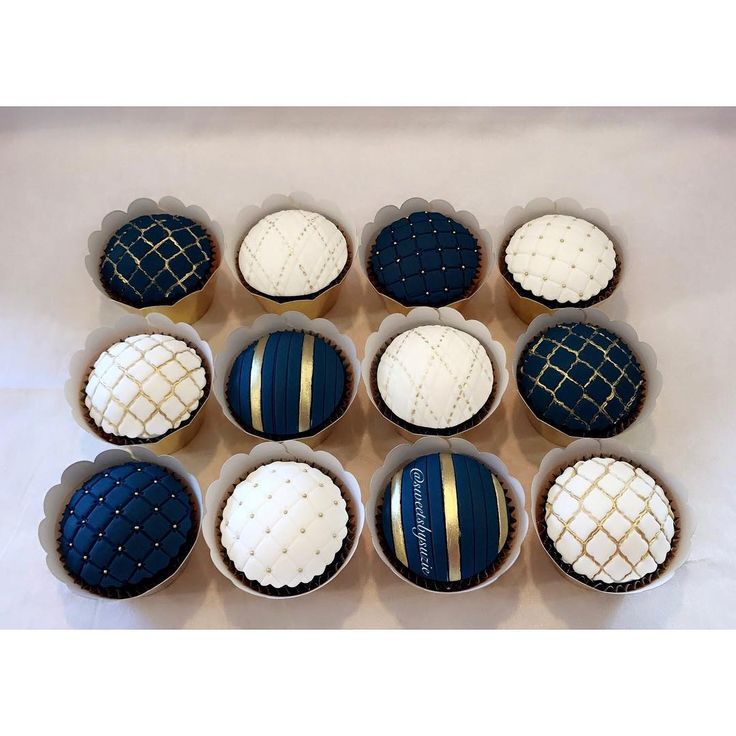 nine cupcakes with blue and white frosting in the shape of balls on top