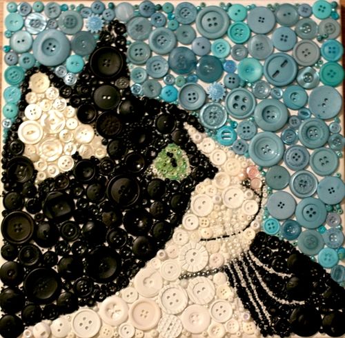 a cat made out of buttons on a wall