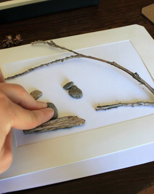 a person is touching rocks on a piece of paper that has been cut into smaller pieces