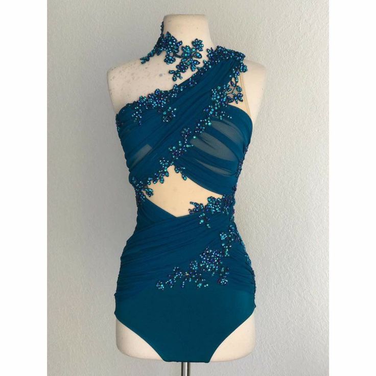 a blue bodysuit with sequins and beads on the back, sitting on a mannequin