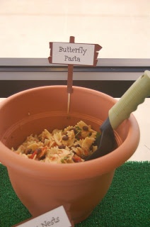 there is a potted plant with food in it and two signs that say butterfly pasta