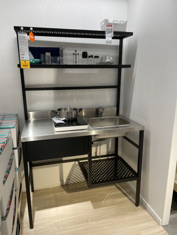 a kitchen area with sink, shelves and drawers