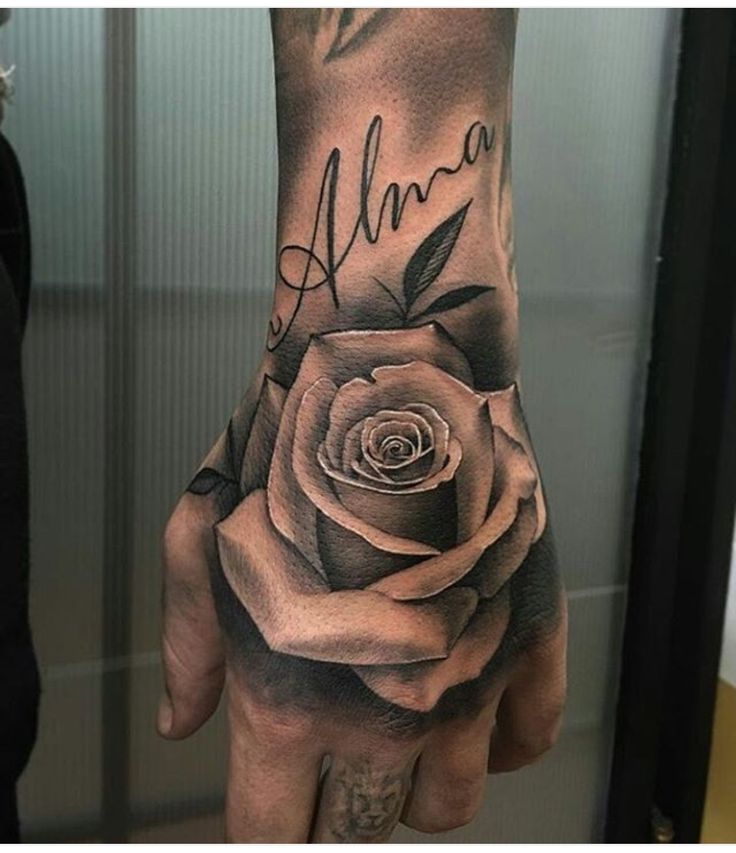 a woman's hand with a rose tattooed on it and the word ann written in cursive writing