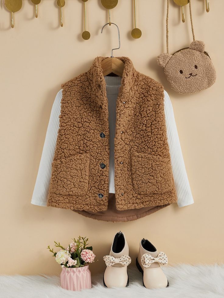 a pair of shoes and a teddy bear hang on the wall next to a coat rack