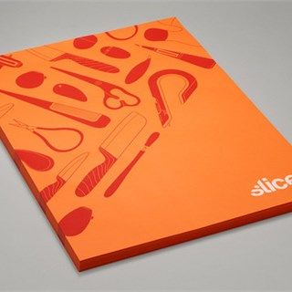 an orange book with scissors and other items on it