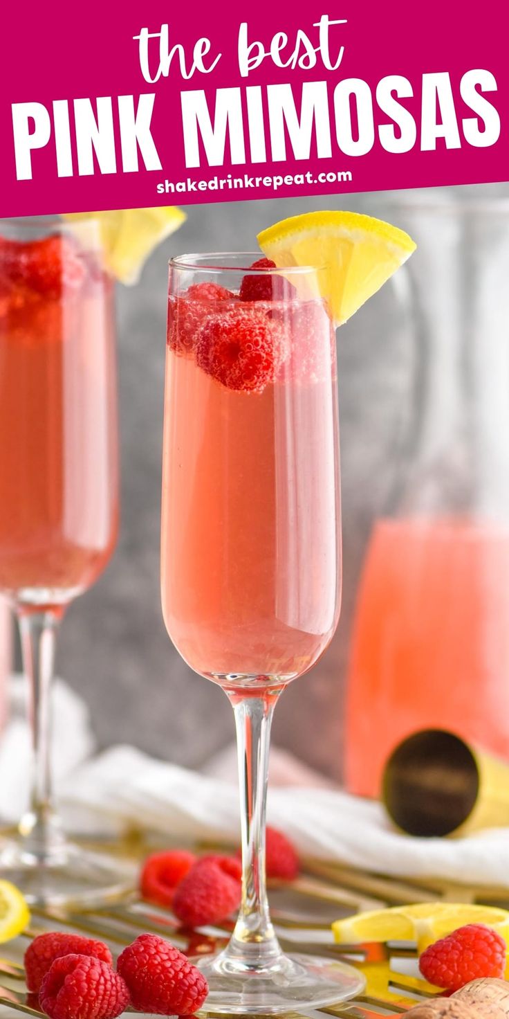 two glasses filled with pink mimosas and topped with raspberries