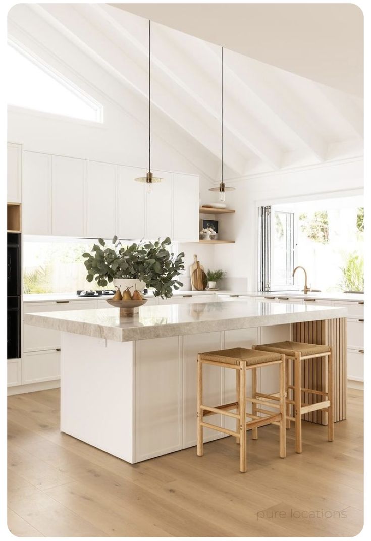 a kitchen with an island and two stools in front of the countertop area