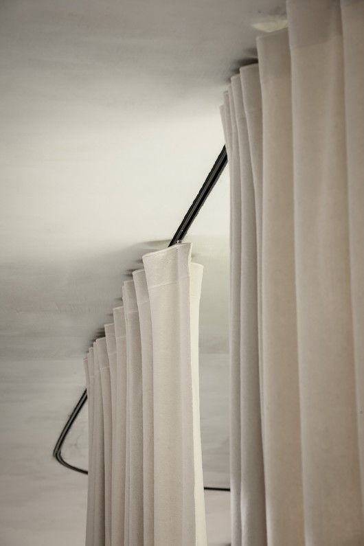 white curtains hanging on the side of a wall