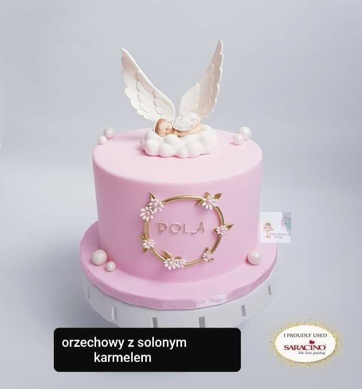 a pink cake with angel decoration on top