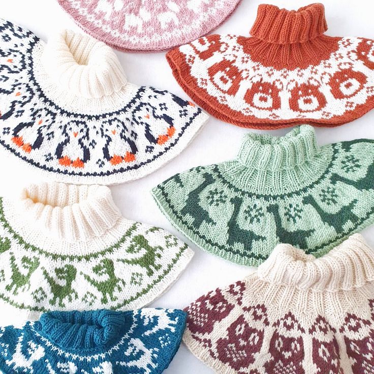 several knitted hats are arranged on a white surface