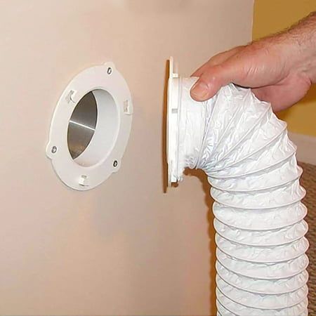 a hand holding a plastic bag over a white wall mounted toilet paper dispenser