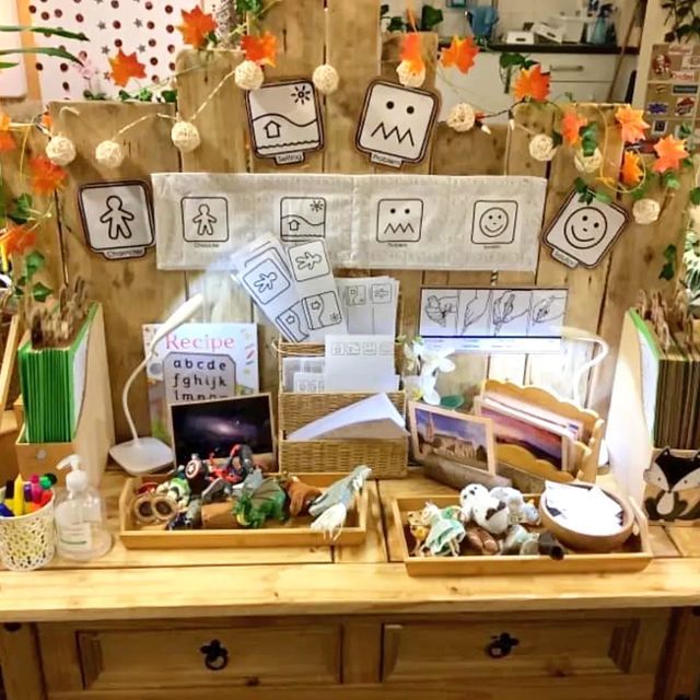 a wooden table topped with baskets filled with toys and paper decorations on top of it