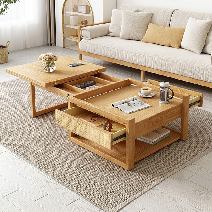 two coffee tables sitting on top of a rug in front of a couch and table